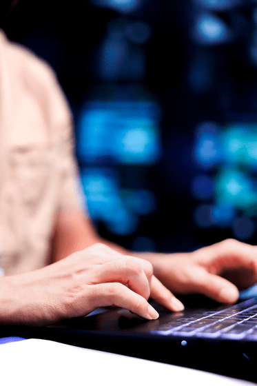 Person typing on laptop with security interface
